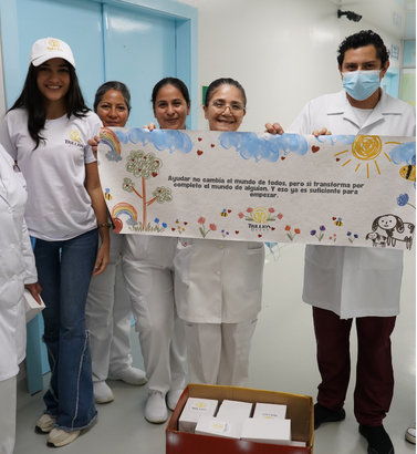 Equipo y personal médico con banner de la fundación en hospital.